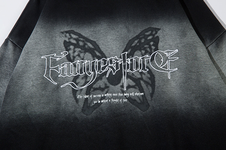 Detail shot of high-definition gothic butterfly chest print with stylized white typography on ombré washed fabric.