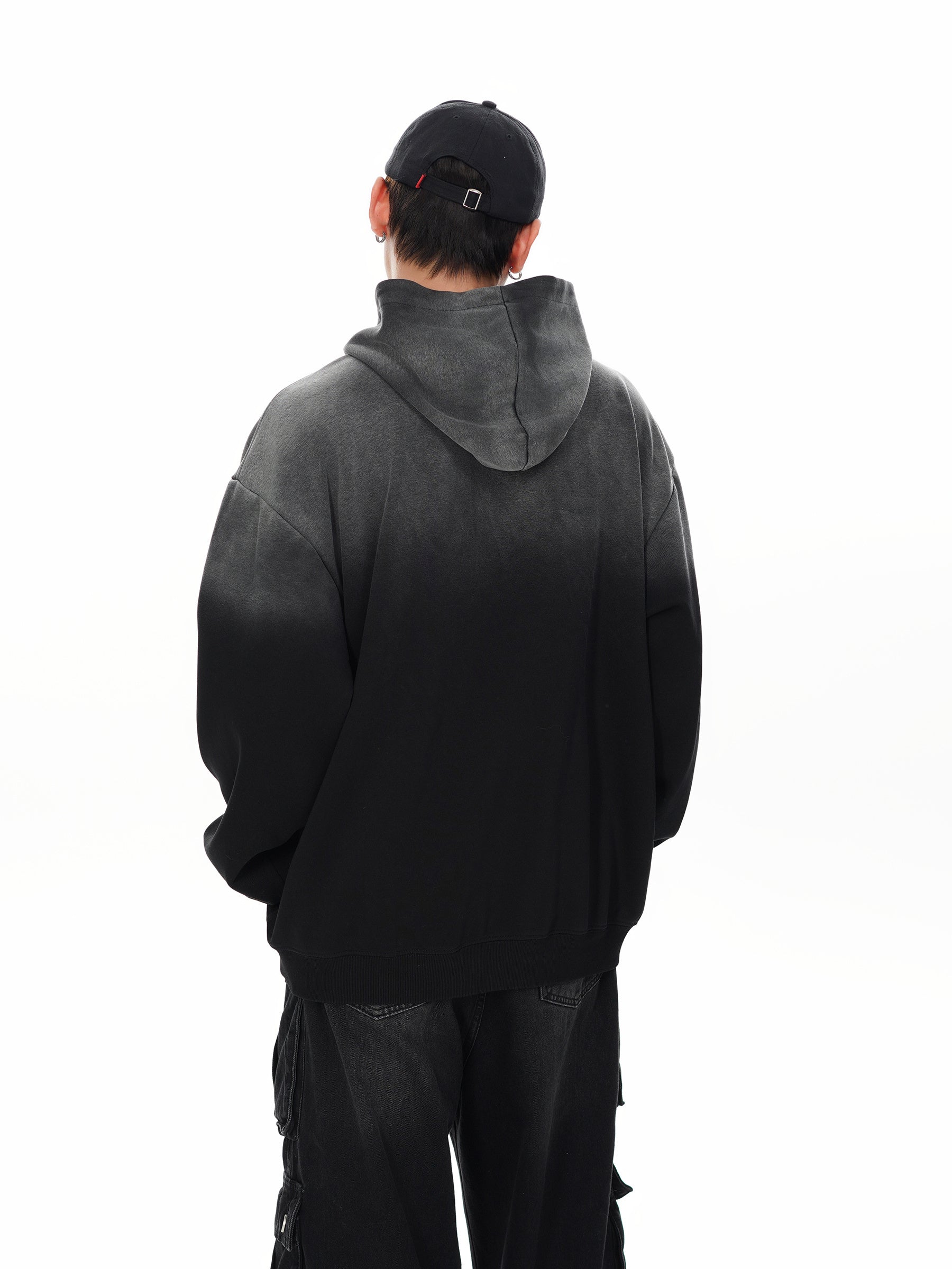 Back view of male model showing the gradient effect of the black hoodie