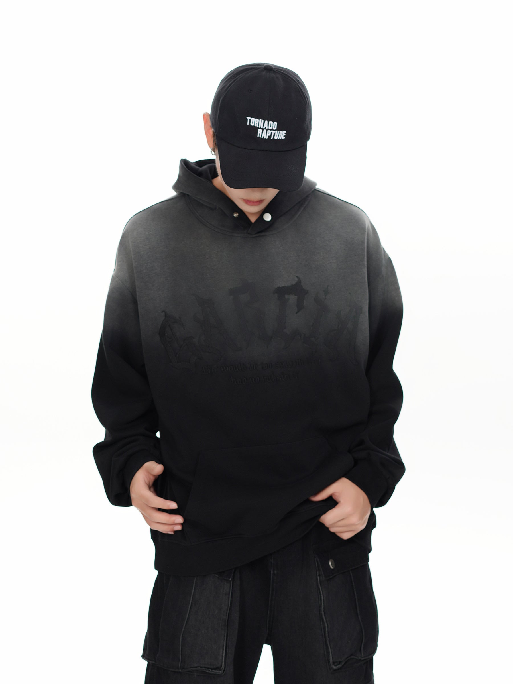 Male model wearing oversized black and grey dip-dye hoodie in grunge streetwear style