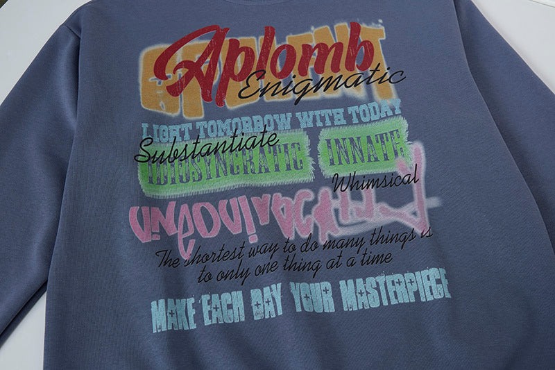 Close-up of vintage graffiti letter print on blue cotton-blend fabric showing texture details.