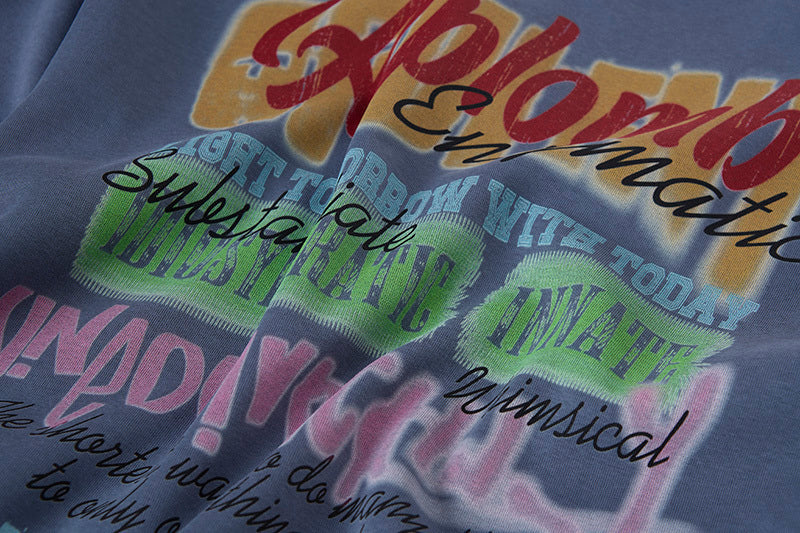 Close-up of vintage graffiti letter print on blue cotton-blend fabric showing texture details.