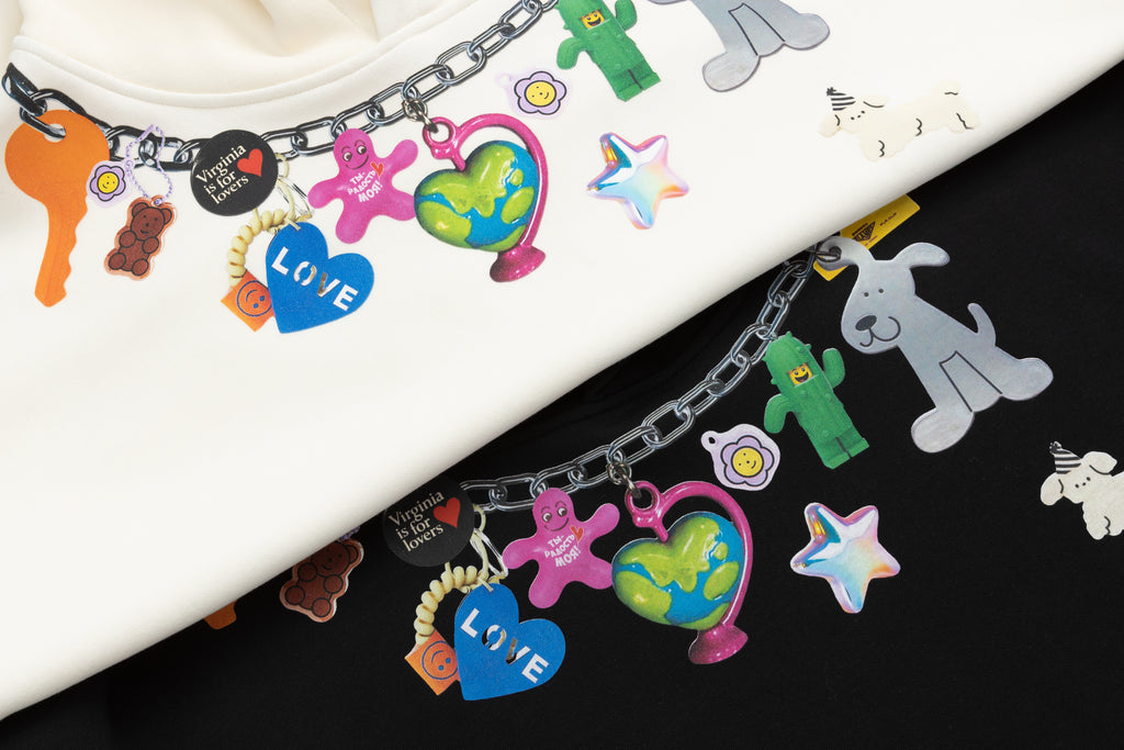 Comparison of black and cream graphic hoodies featuring a Y2K style charm necklace print around the neck.