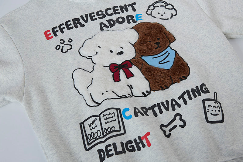 Close-up of textured chenille embroidery showing white and brown puppies with red bow tie.