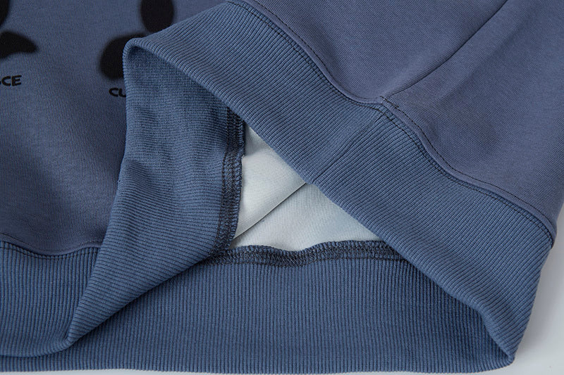 Close-up of a blue hoodie with a brand logo on a light gray background